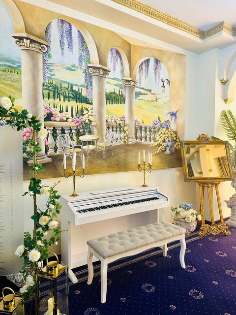Colțul cu pian alb și pictură murală din salon